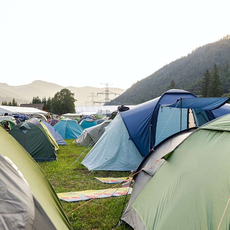 Campingplatz mit Zelten im Regen. Besser mit einer Regenversicherung.